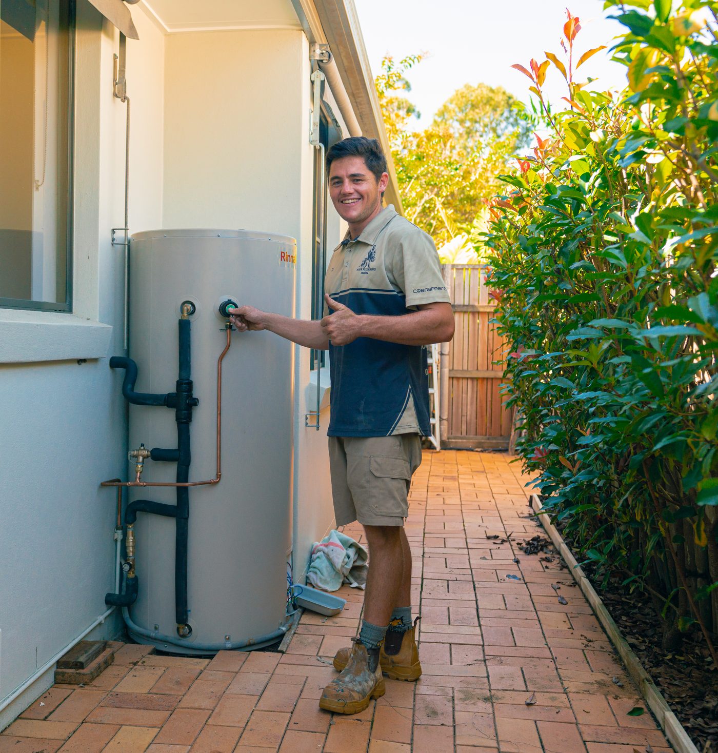 Your Plumbing Mates plumber beside a newly installed hot water tank