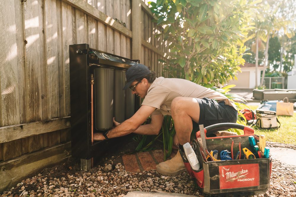 Plumber connecting the filter housing to the mains